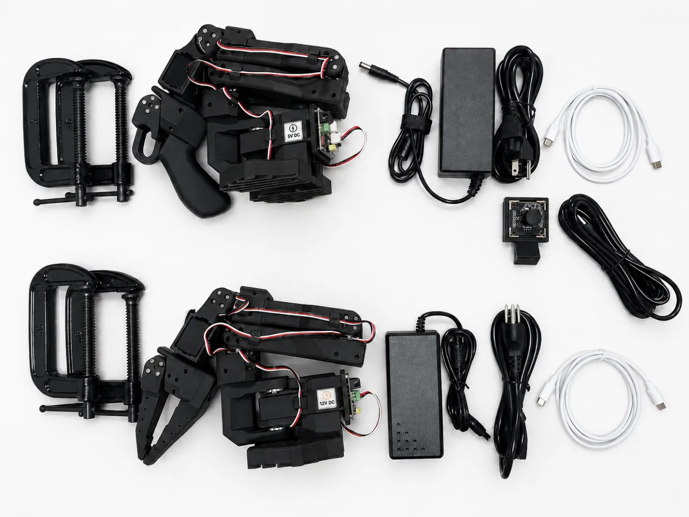 Everything in the black SO-ARM101 kit laid out: two arms, USB camera, power supplies, cables and clamps