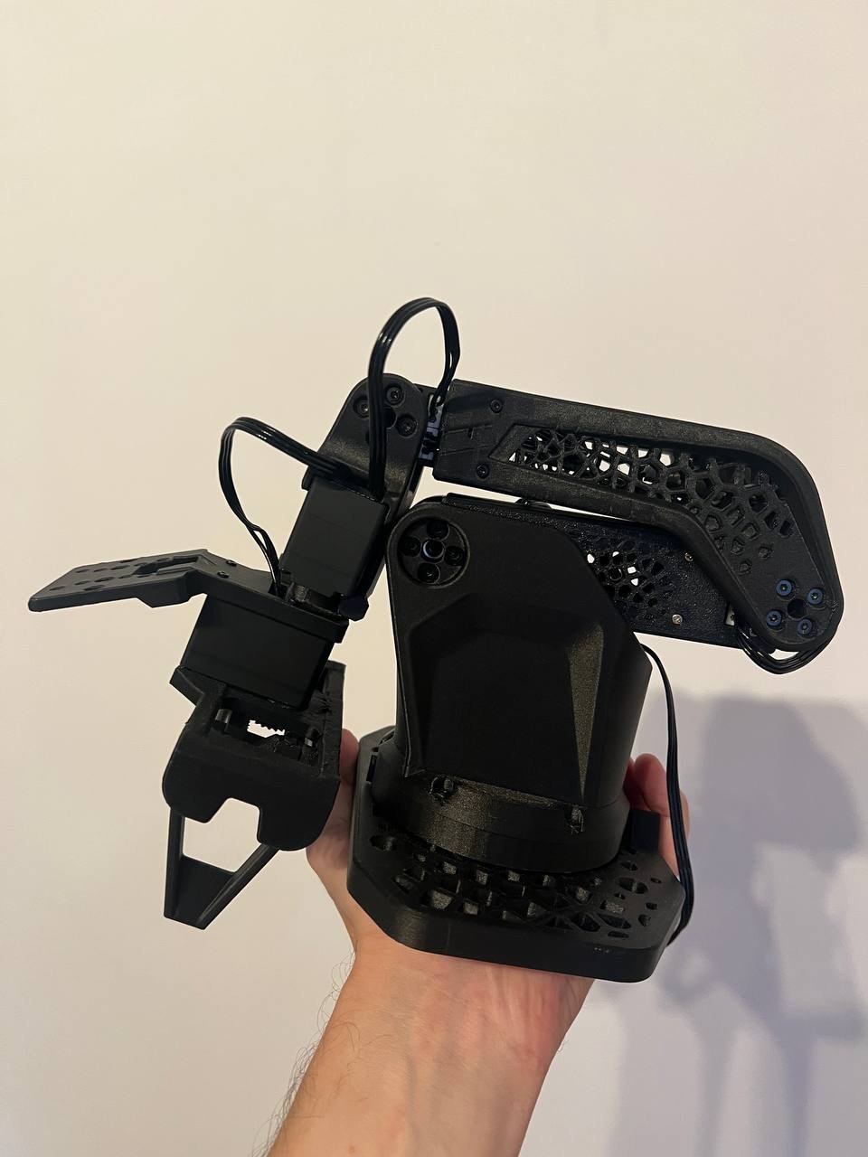 The assembled follower held in one hand: PET-CF lattice links, the parallel gripper and the base.