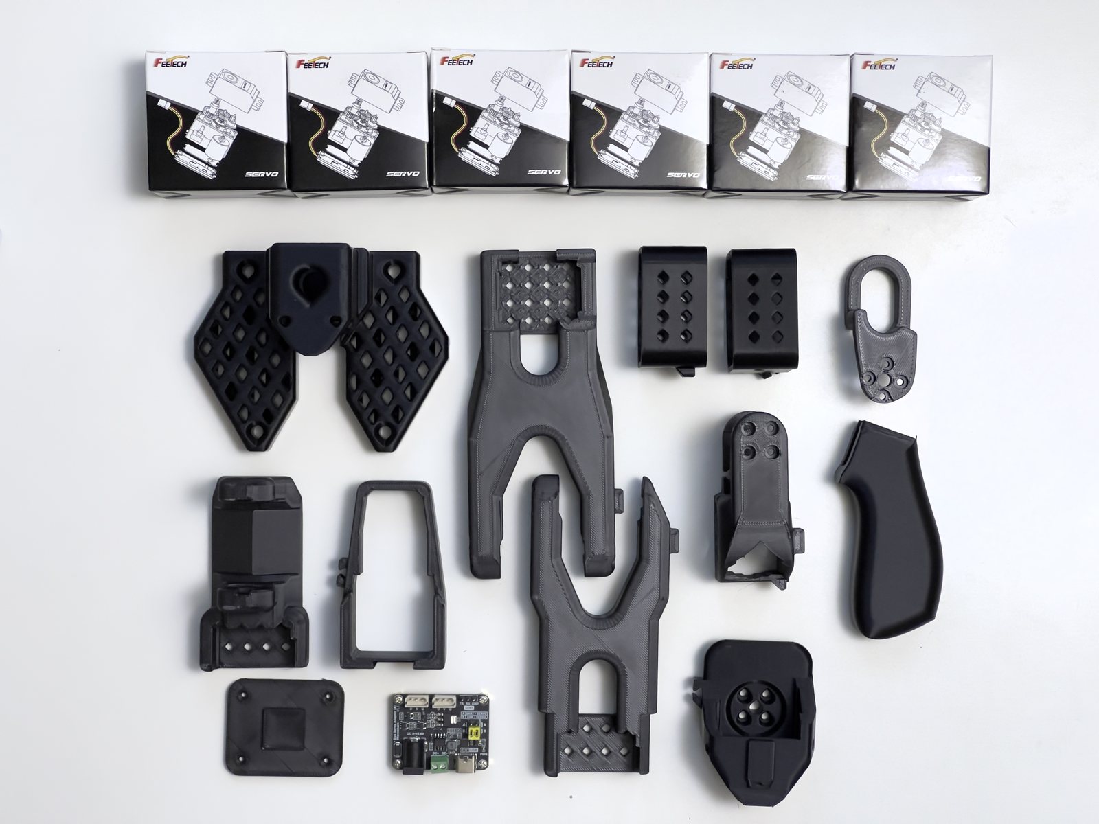 The leader arm: black printed parts, the handle, its driver board and six servos.